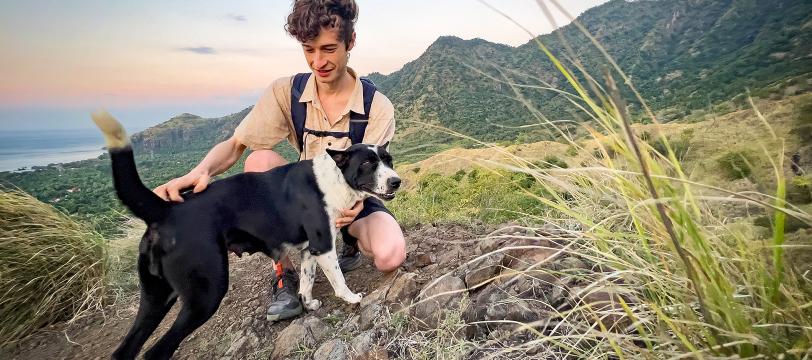 A man sitting on a rock with a dog