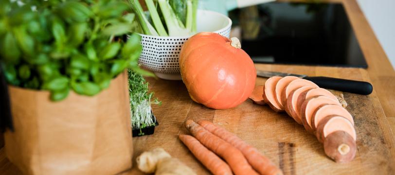 A pumpkin and carrots on a table