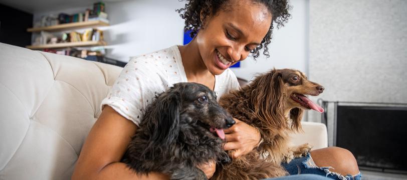 A woman holding two dogs