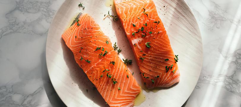 A plate of salmon with herbs on it