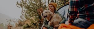 A woman holding a dog in a tent