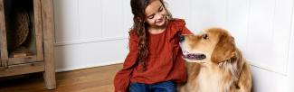 A girl sitting on the floor with a dog