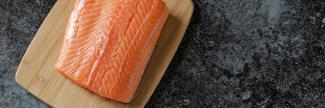 Piece of fish on a wooden cutting board image - Omega Fatty Acids